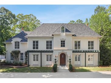 Stunning white brick home featuring a grey roof, multiple windows, arched entry and manicured lawn at 1658 Mount Paran Nw Rd, Atlanta, GA 30327
