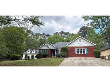 Charming brick home with green shutters, well-maintained lawn, and lush trees at 1721 Druids Se Xing, Conyers, GA 30013