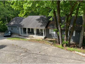 Charming single-story home with a covered front porch and mature trees at 165 Holly Ct, Loganville, GA 30052