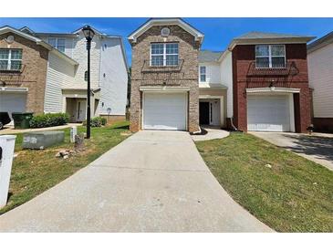 A charming two-story townhome featuring a one-car garage and well-maintained front lawn at 4316 Sw Notting Hill Sw Dr, Atlanta, GA 30331