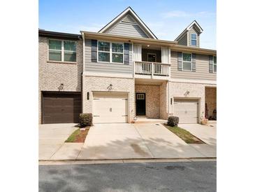 Charming townhome featuring gray and brick exterior, garage, balcony, and landscaped front at 137 White Mountain Pass, Mcdonough, GA 30252