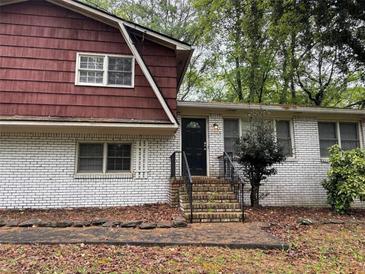 Inviting two-story house with a brick facade, complemented by a red-painted upper level at 2858 Davidson Dr, Lithonia, GA 30058