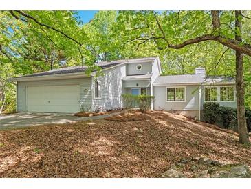 Charming home featuring a two-car garage, a landscaped yard and a wooded lot at 7320 Oak Arms Dr, Villa Rica, GA 30180