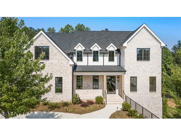 Striking exterior view of a two-story brick home with black trim and manicured landscaping at 117 Owens Mill Pl, Canton, GA 30115