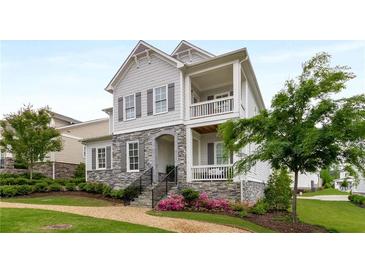Charming home showcasing a stone facade, dual balconies, manicured landscaping, and a welcoming walkway at 2004 Haley Walk, Woodstock, GA 30188