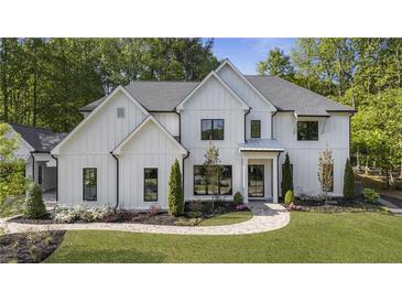 Stunning two-story home with a white board and batten exterior and manicured front yard at 214 Kenneth Drive, Alpharetta, GA 30009
