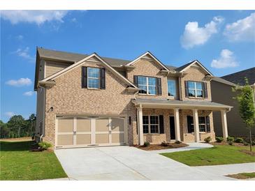 Inviting two-story brick home with a two-car garage and a charming front porch at 3305 Linstead Ct, Loganville, GA 30052