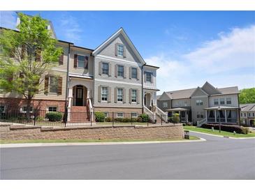 Attractive townhome exteriors feature brick and siding accents, complemented by manicured landscaping, and beautiful architectural details at 265 Trecastle Sq, Canton, GA 30114