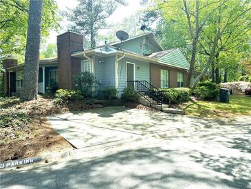 Charming two-story home with a brick chimney and a well-maintained front yard surrounded by lush trees at 4828 Westridge Dr, Norcross, GA 30093