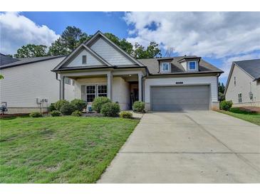 Charming single-Gathering home featuring a two-car garage, and a welcoming front porch with manicured landscaping at 5650 Bergeson Ways, Cumming, GA 30028