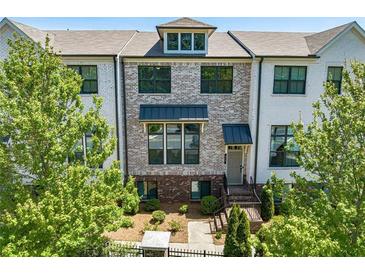 Charming townhome with brick and white painted brick exterior, lush landscaping, and a welcoming entrance at 820 Fair View Cir, Roswell, GA 30076
