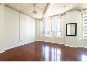 Bright, open living room with hardwood floors and large windows offering ample natural light at 20 Marietta St. Nw #12D, Atlanta, GA 30303