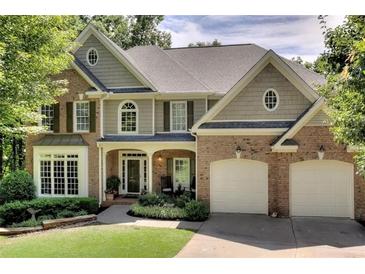 Charming two-story home featuring brick and siding, a well-manicured lawn, and an attached two-car garage at 6795 Preston Glen Dr, Alpharetta, GA 30005