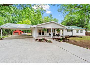 Charming ranch-style home featuring a carport, covered porch, and well-maintained landscaping at 5766 Macland Rd, Powder Springs, GA 30127