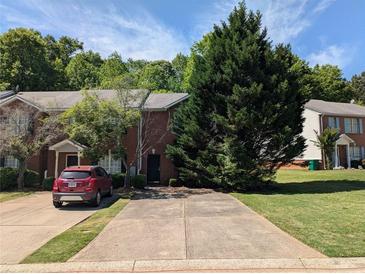 Townhome with brick facade, driveway, and mature landscaping in a residential neighborhood at 3789 Waldrop Ln, Decatur, GA 30034