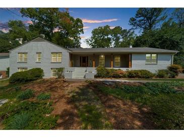 Charming brick home with a welcoming front porch and mature trees, perfect for outdoor relaxation at 7300 Wynhill Dr, Sandy Springs, GA 30328