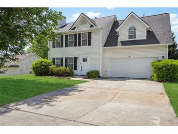 Charming two-story home featuring a two car garage, manicured lawn and inviting front entrance at 10423 Commons Xing, Jonesboro, GA 30238