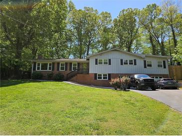 Charming split-level home with brick accents, well-maintained lawn, and mature trees at 1513 Wildwood Dr, Acworth, GA 30102