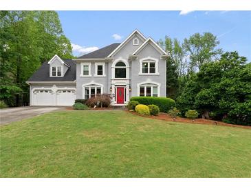 Stately two-story home with a well-manicured lawn, a two car garage and a red front door at 681 Braidwood Nw Ter, Acworth, GA 30101