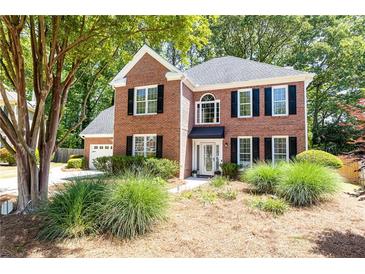 Charming two-story brick home featuring lush landscaping and a welcoming entrance at 11140 Brookhollow Trl, Alpharetta, GA 30022