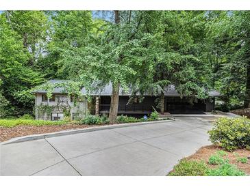 Charming home with lush landscaping and a long driveway leading up to the entrance at 2361 Woodward Nw Way, Atlanta, GA 30305