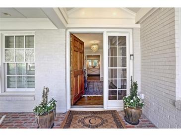 Elegant front door with sidelight, transom, and brickwork entryway leads into a bright, inviting home at 1299 W Wesley Nw Rd, Atlanta, GA 30327