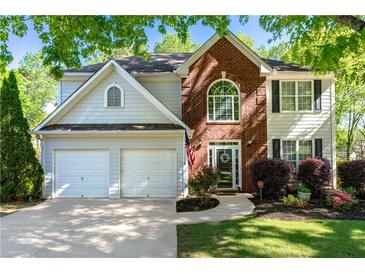 Charming two-story home featuring a two-car garage, brick accents, manicured lawn and beautiful shrubbery at 2264 Howell Farms Nw Trl, Acworth, GA 30101