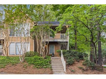 Inviting two-story townhouse with a landscaped front yard and cozy balcony, perfect for enjoying the surrounding greenery at 2308 Country Park Se Dr, Smyrna, GA 30080