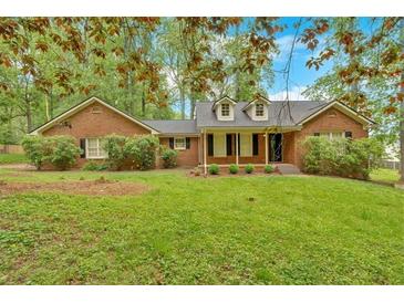 Charming brick home featuring a well-maintained lawn and mature trees at 151 Mark Se Ln, Smyrna, GA 30082