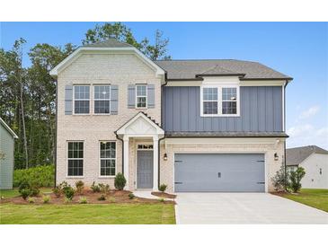 Charming two-story home featuring a brick facade, gray siding, and a two-car garage at 5383 Heron Bay Blvd, Locust Grove, GA 30248