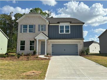 Charming two-story home with a combination brick and siding exterior, attached garage, and inviting curb appeal at 5383 Heron Bay Blvd, Locust Grove, GA 30248
