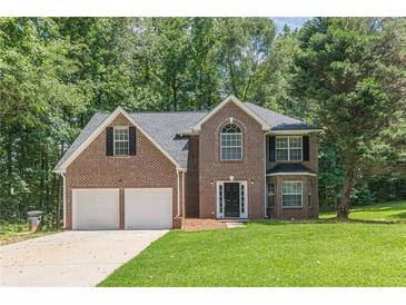 Traditional two-story brick home with a well-manicured lawn and an attached two-car garage at 99 Ashtonbrook Dr, Mcdonough, GA 30252