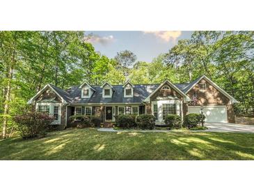 Charming brick home featuring bay windows and a well-manicured lawn with mature trees at 4703 Waverly Walk, Douglasville, GA 30135