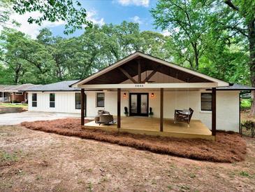Charming single-story home with a lovely covered front porch and swing, offering a welcoming curb appeal at 5840 Crabapple Sw Dr, Mableton, GA 30126