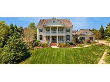 Charming two-story home with manicured lawn, lush landscaping, and double front porch at 210 Tifton Ln, Roswell, GA 30075