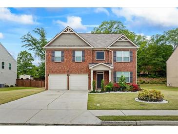 Inviting two-story brick home with a well-manicured lawn and a two-car garage at 3573 Stonebranch Ln, Loganville, GA 30052