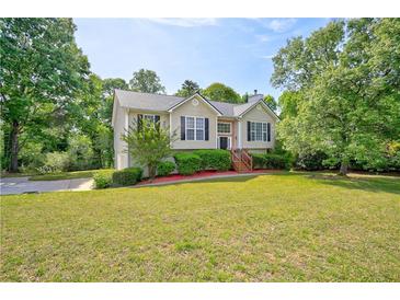 Charming home with a manicured lawn and mature trees in a suburban setting at 4199 Wyndham Park Way, Buford, GA 30519