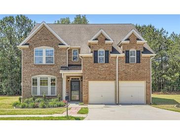 Inviting two-story brick home with a well-manicured lawn and a two-car garage at 23 Dynasty Dr, Fairburn, GA 30213