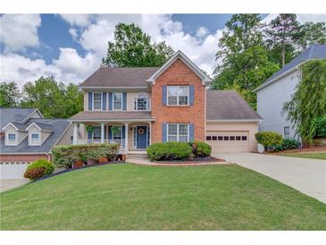 Charming two-story brick home with a well-manicured lawn and inviting front porch at 1099 Mount Water Ln, Lawrenceville, GA 30043