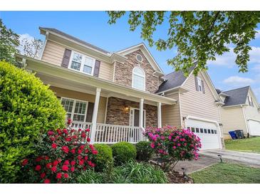 Inviting two-story home featuring a covered front porch, stone accents, and well-maintained landscaping at 2164 Caneridge Sw Dr, Marietta, GA 30064