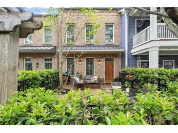 Charming brick townhouse features a lovely patio with iron fence and ample seating area at 719 Hammond Dr, Woodstock, GA 30188