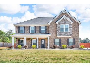 Charming two-story brick home with a well-manicured lawn and inviting front porch at 206 Prescott St, Locust Grove, GA 30248