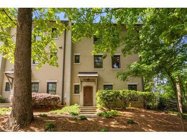 Exterior of multi-story townhouse with brick facade, well-maintained landscaping, and a covered front entrance at 217 Knob Hills Cir, Decatur, GA 30030