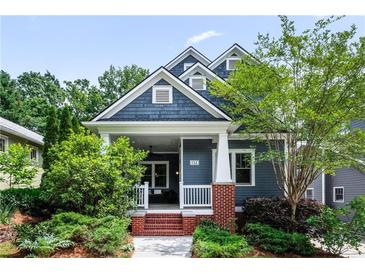 Charming two-story home with landscaped yard, brick steps, a porch swing, and stylish blue siding at 132 Olympic Pl, Decatur, GA 30030