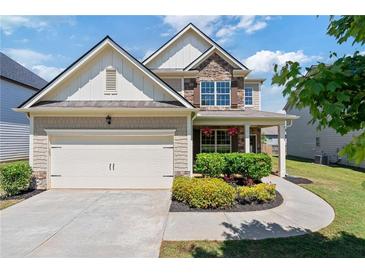 Charming two-story home with a two-car garage and manicured landscaping at 3625 New River Ct, Cumming, GA 30040