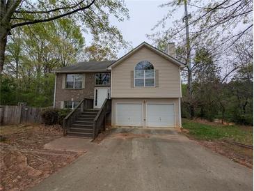 Charming two-story home featuring a two-car garage, brick accents, and a welcoming front porch at 3413 Creekview Dr, Rex, GA 30273