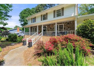 Charming two-story home featuring a stone facade, covered porch, and beautifully landscaped front yard at 546 Wagon Wheel Climb, Lawrenceville, GA 30044