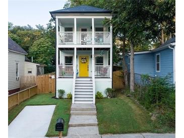 Charming two-story home with a welcoming yellow front door and dual front porches, offering curb appeal at 955 Coleman Sw St, Atlanta, GA 30310