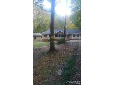 Inviting one-story home featuring a screened-in porch nestled among mature trees at 40 Burma Rd, Mcdonough, GA 30252