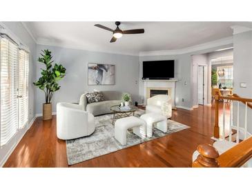 Bright living room with fireplace, ceiling fan, hardwood floors, and gray walls at 833 Charles Bank Se Ave, Atlanta, GA 30312